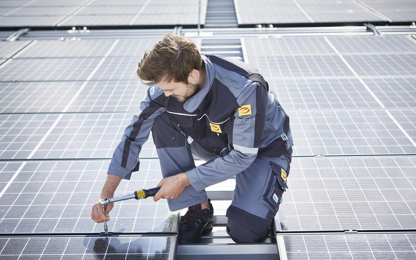 E-CHECK E-Mobilität - Mitarbeiter montiert auf dem Dach die neuen Solarmodule &middot; Finke Elektro