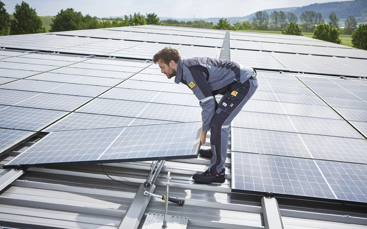 E-CHECK PV - Mitarbeiter installiert Solarzellen auf dem Dach &middot; Finke Elektro