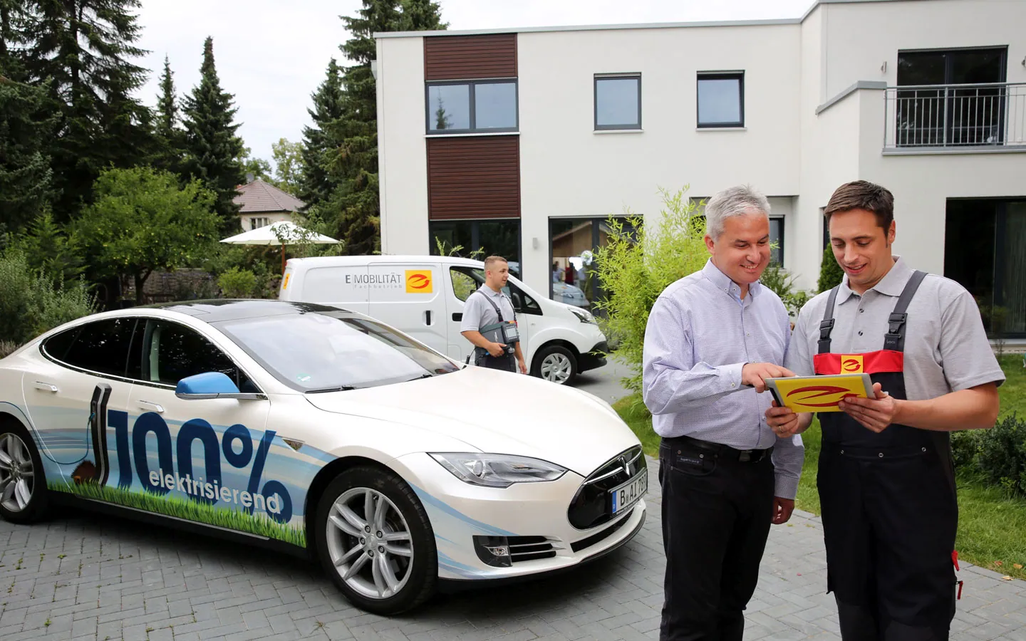 E-Mobilität - Mitarbeiter mit Kunden vor Elektrofahrzeugen 100% elektrisch &middot; Finke Elektro